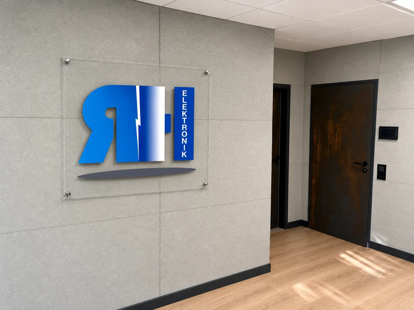 Logo der RH Elektronik GmbH auf einer Acrylglastafel im Empfangsbereich